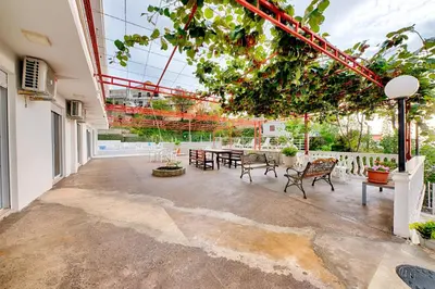 a patio with a table and chairs in a building at Vila Nikezić in Sutomore