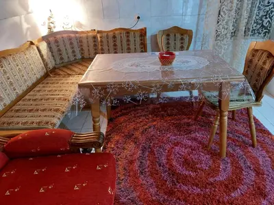 a dining room table and chairs with a red rug at Airport home Radinovic in Podgorica
