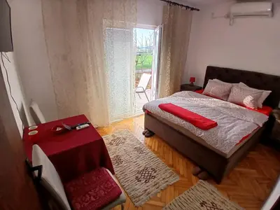a bedroom with a bed with red pillows on it at Airport home Radinovic in Podgorica