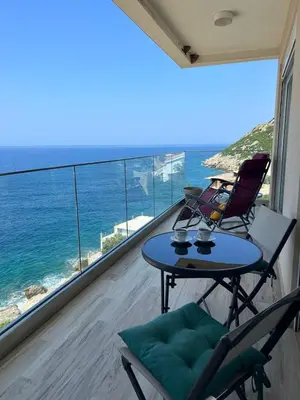 a balcony with a table and chairs and the ocean at Your Home Montenegro in Dobra Voda