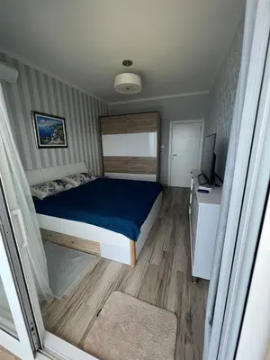 a small bedroom with a bed and a television at Your Home Montenegro in Dobra Voda