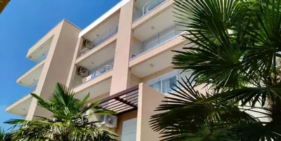 a tall building with palm trees in front of it at Your Home Montenegro in Dobra Voda