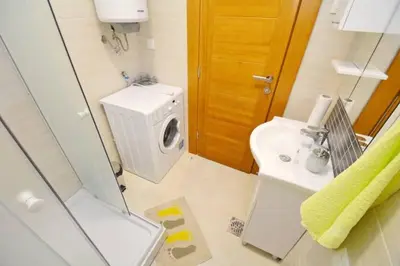 a bathroom with a washing machine and a sink at Belveder Apartments in Budva