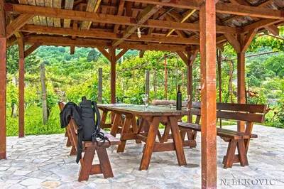 a wooden table in a pavilion with a backpack on it at Guesthouse Bato in Virpazar