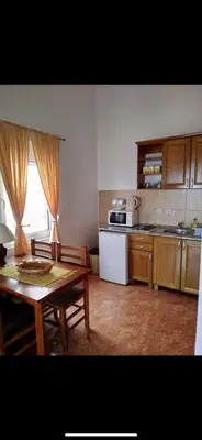 a kitchen with a table and a kitchen with a stove and microwave at Majero Apartments in Utjeha