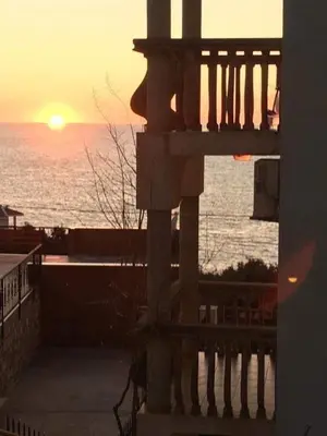 a view of the ocean from a balcony with the sunset at Majero Apartments in Utjeha