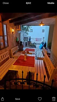 a patio with wooden benches and a table and a fireplace at Majero Apartments in Utjeha