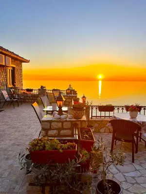 a sunset over the water with tables and chairs at Apartments Antigona Old Town in Ulcinj