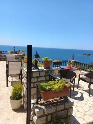 a patio with tables and chairs and the ocean at Apartments Antigona Old Town in Ulcinj