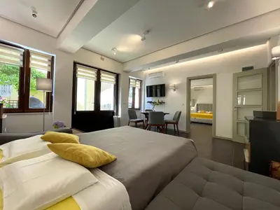 a bedroom with a large bed and a living room at Kotor Center W in Kotor