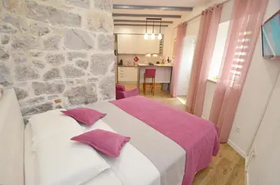 a bedroom with a bed and a stone wall at Kotor Center W in Kotor