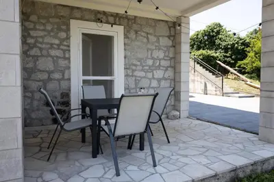 a patio with a black table and chairs at Green Harmony in Tivat