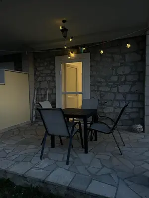 a table and chairs on a patio at night at Green Harmony in Tivat