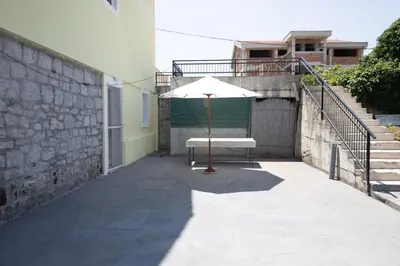 a patio with an umbrella and stairs and a building at Green Harmony in Tivat