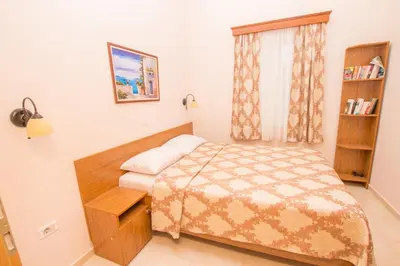 a small bedroom with a bed and a book shelf at Villa Del Mar in Sutomore