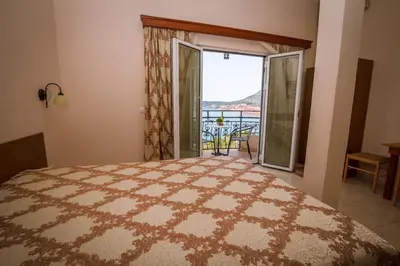 a bedroom with a large bed and a large window at Villa Del Mar in Sutomore
