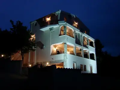 a large white building with lights on it at night at Villa Del Mar in Sutomore