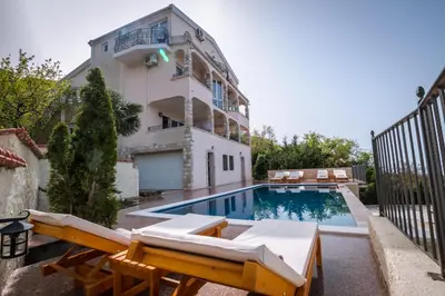 an apartment with a swimming pool and a building at Villa Del Mar in Sutomore