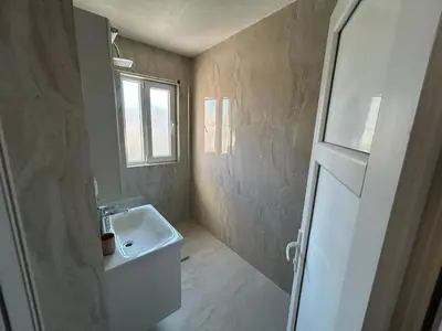 a small bathroom with a sink and a window at Apartmani Alexandra in Budva