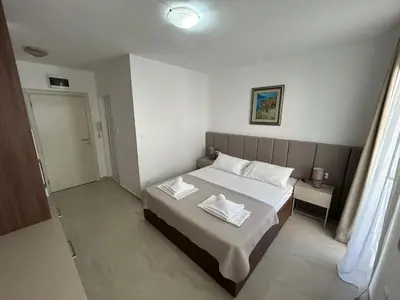 a bedroom with a bed with two white towels on it at Apartmani Alexandra in Budva
