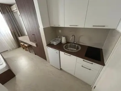 a small kitchen with a sink and white cabinets at Apartmani Alexandra in Budva