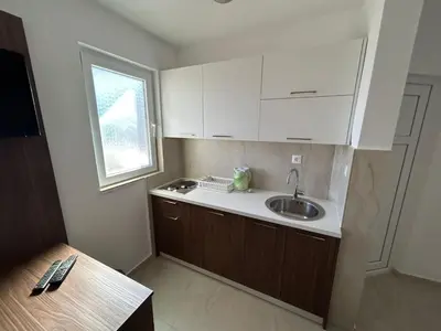 a small kitchen with a sink and a window at Apartmani Alexandra in Budva