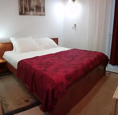 a bedroom with a large bed with a red blanket at 