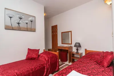 a bedroom with two red beds and a mirror at 