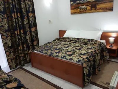 a bedroom with a bed with a blanket and a picture on the wall at 