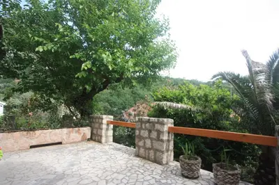 a patio with a fence and trees and a giraffe at Villa Masha in Rijeka Reževići