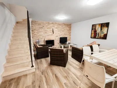 a living room with a staircase and a table and chairs at Villa Masha in Rijeka Reževići