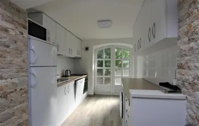 a kitchen with white appliances and a brick wall at Villa Masha in Rijeka Reževići