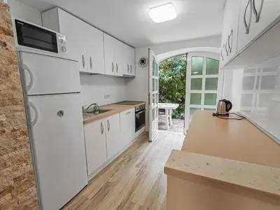 a kitchen with white cabinets and a white refrigerator at Villa Masha in Rijeka Reževići