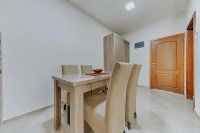 a dining room with a wooden table and chairs at Sea Garden Apartments in Dobra Voda