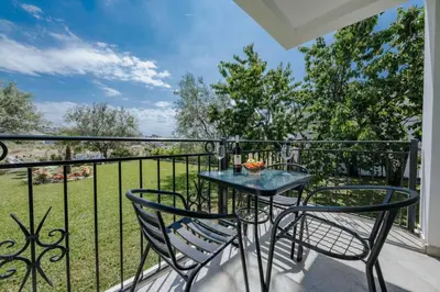 a patio with a table and chairs on a balcony at Sea Garden Apartments in Dobra Voda