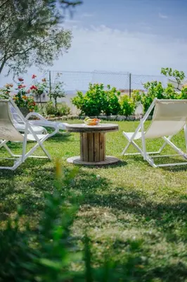 two chairs and a table in the grass at Sea Garden Apartments in Dobra Voda