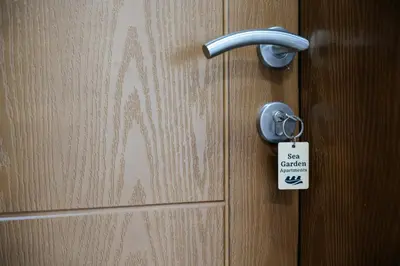 a door with a door knob and a tag on it at Sea Garden Apartments in Dobra Voda