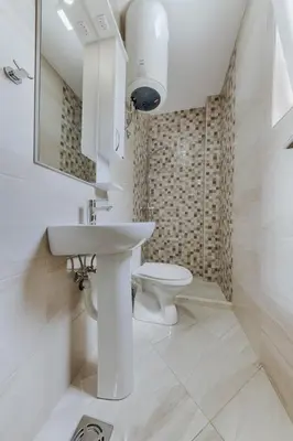 a white bathroom with a sink and a toilet at Sea Garden Apartments in Dobra Voda