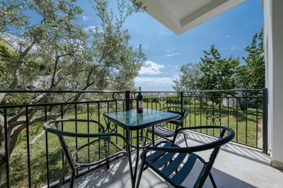 a patio with a table and chairs on a balcony at Sea Garden Apartments in Dobra Voda