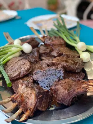 a plate of meat and vegetables on a table at Apartments Villa Andjela in Budva