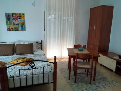 a bedroom with a bed and a table and a desk at Apartments Villa Andjela in Budva
