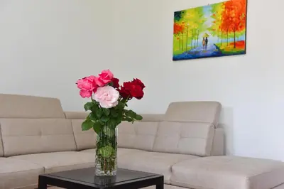 a vase of flowers on a table in a living room at Apartmani Mihovic - JAZ in Budva
