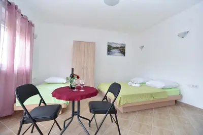 a room with a table and chairs and a bed at Apartmani Mihovic - JAZ in Budva
