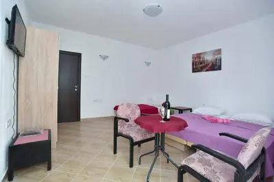 a room with a table and chairs and a bed at Apartmani Mihovic - JAZ in Budva