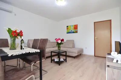 a living room with a couch and a table with flowers at Apartmani Mihovic - JAZ in Budva