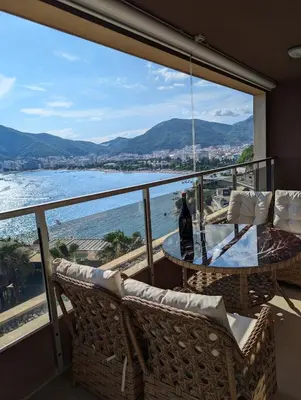 a balcony with a table and chairs and a view of the ocean at Lux Apartments Harmonia in Budva