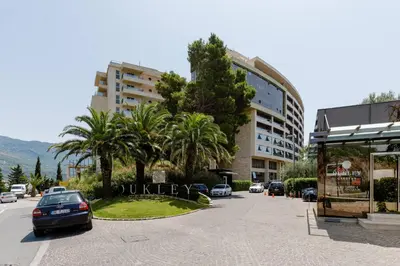a car parked in a parking lot next to a building at Lux Apartments Harmonia in Budva