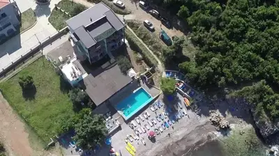 a group of people standing around a swimming pool at Arabela Apartments in Utjeha