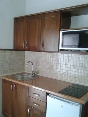 a kitchen with a sink and a microwave at Arabela Apartments in Utjeha