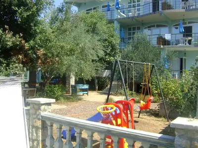 a playground in a yard with a swing at Arabela Apartments in Utjeha